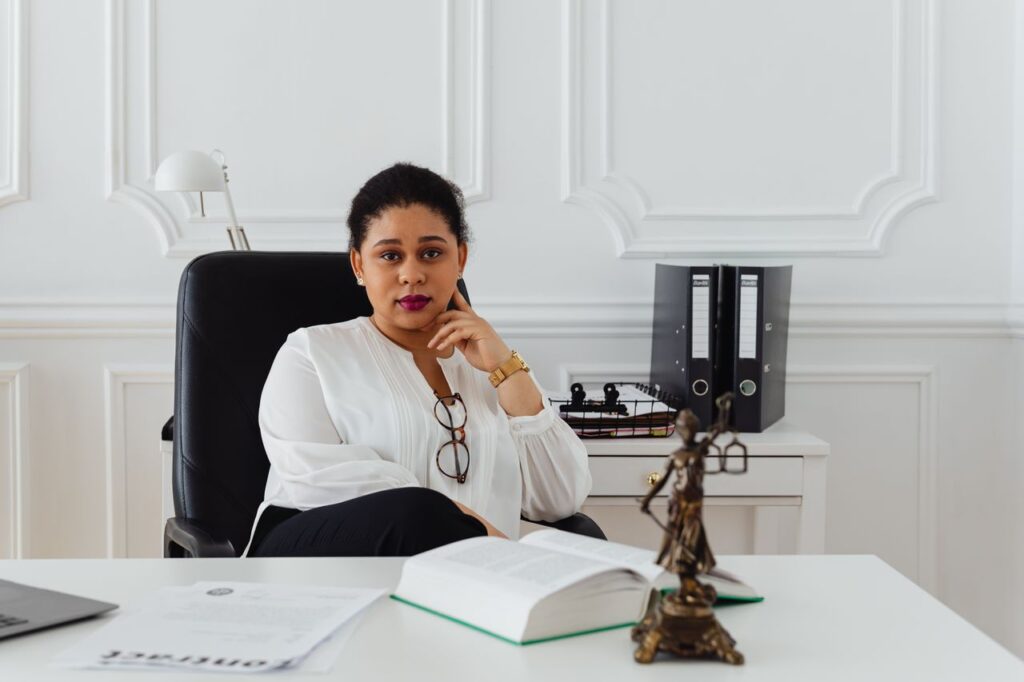 Portrait of a professional lawyer sitting confidently in a modern office, conveying authority.